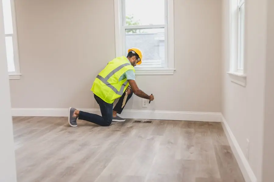 Inspection minutieuse d'une prise murale par un professionnel en tenue de sécurité