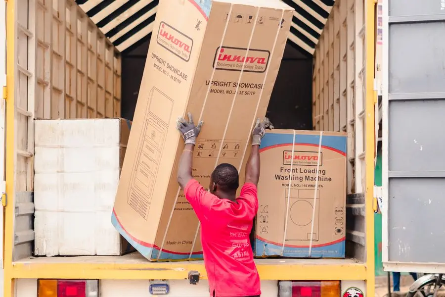 Déménageur chargeant des cartons d'électroménager dans un camion de déménagement