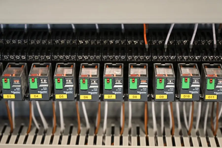Rangée de relais électriques et de câblage organisé dans une armoire de tableau électrique